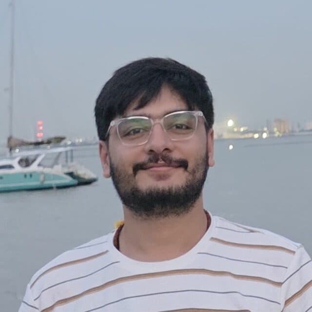 Takshak Mudgal, smiling, by the sea